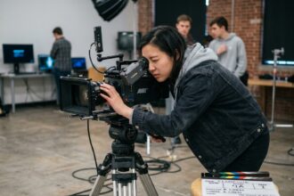 Étudiante en cinéma réglant une caméra professionnelle dans un studio de formation audiovisuelle