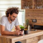 Man typing a text message using smart phone