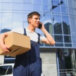 Postman with parcel box. Postal delivery service.