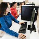 Young students using computers during business class at school - Focus on girl face